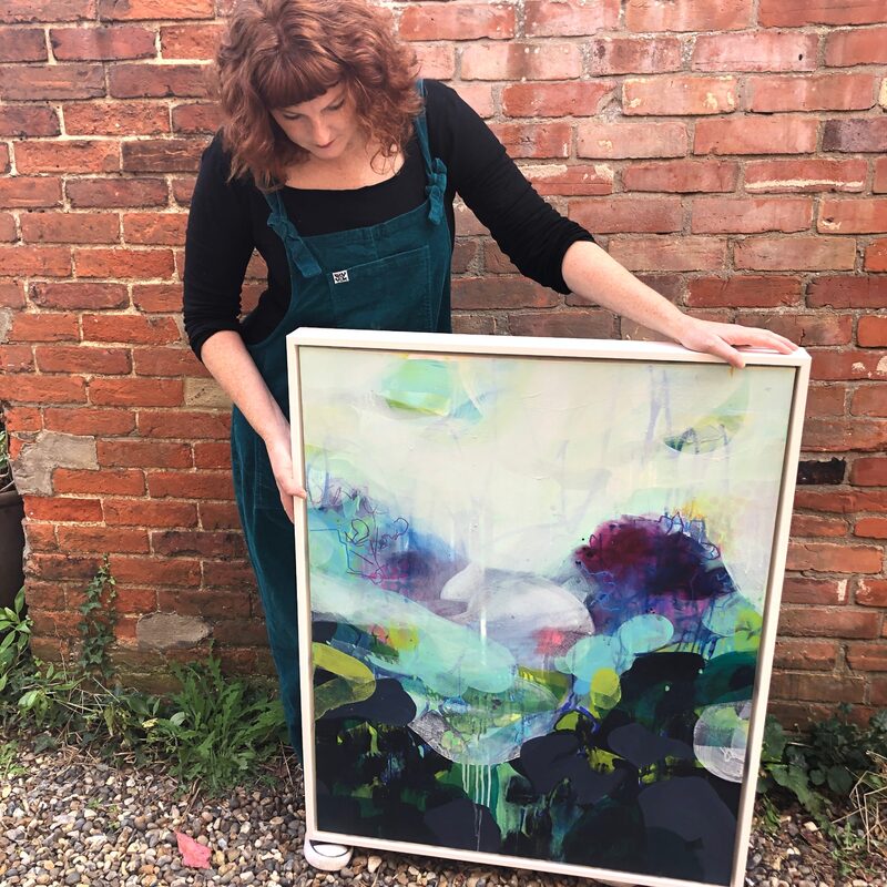 Lisa Henshall holding one of her paintings